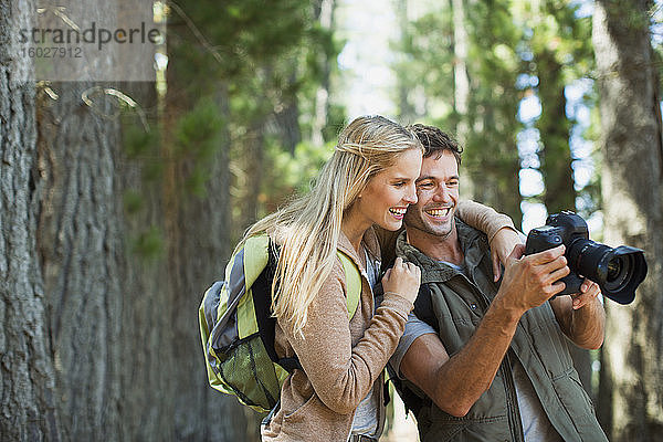 Ehepaar betrachtet Digitalkamera im Wald