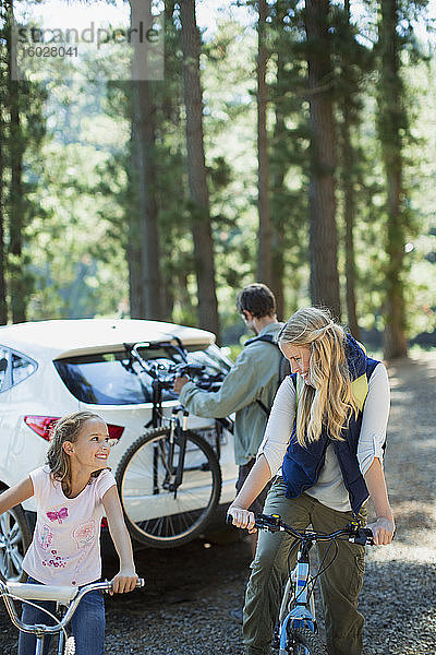Glückliche Familie mit Fahrrädern im Wald