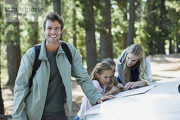 Lächelnder Mann mit Familie im Wald