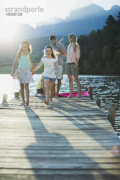 Familie beim Spaziergang am Dock über den See