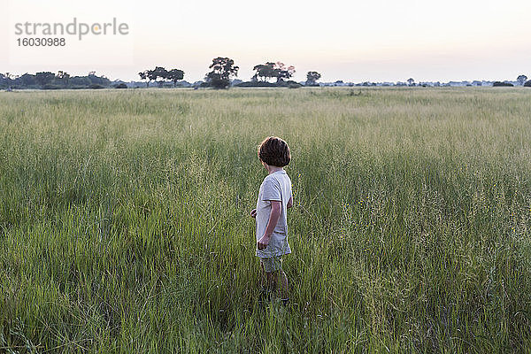 Sechsjähriger Junge im Grasfeld  Botswana