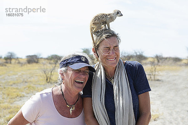 erwachsene Frau mit Erdmännchen auf dem Kopf  Kalahari-Wüste  Makgadikgadi-Salzpfannen  Botswana