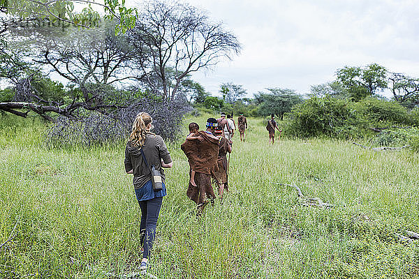Touristen auf einem Wanderweg mit Mitgliedern des San-Volkes  Buschmännern.