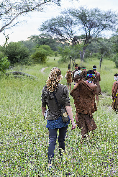 Touristen auf einem Wanderweg mit Mitgliedern des San-Volkes  Buschmännern.