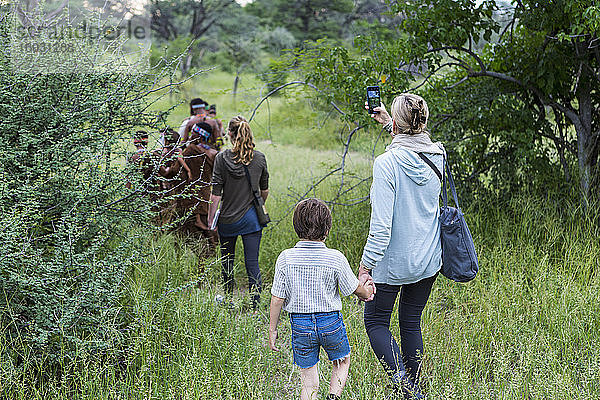 Ein Junge und seine Mutter  Touristen auf einem Wanderweg  die Angehörigen des Volkes der San folgen  Buschmänner.