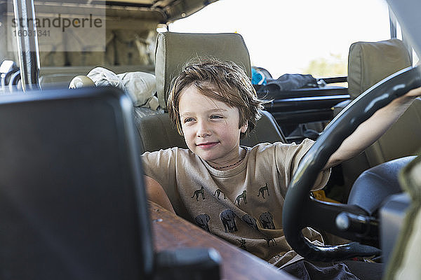 Porträt eines sechsjährigen Jungen in einem Safari-Fahrzeug