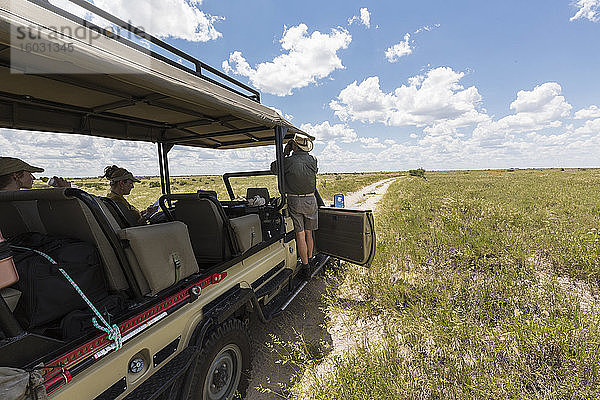 Safari-Führer und Fahrzeug auf unbefestigter Straße