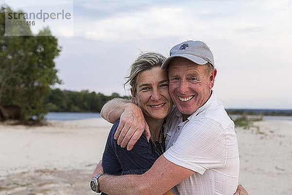 Ein reifes Paar  das sich an den Ufern des Sambesi umarmt.