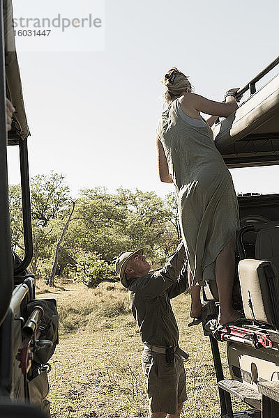 Eine Frau steigt in ein Safari-Fahrzeug.