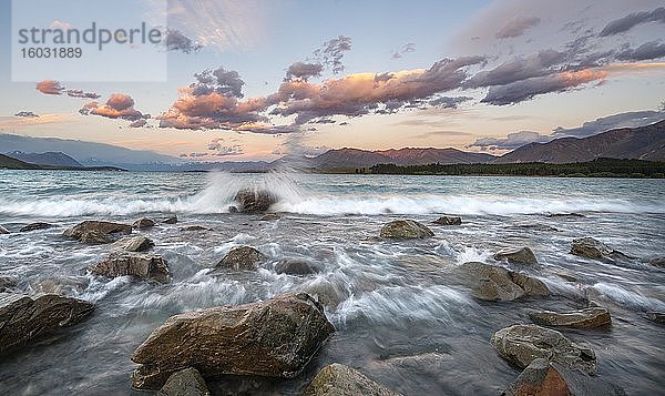 Steine am Ufer  See mit Wellengang bei Sonnenuntergang  Langzeitbelichtung  Lake Tekapo  Canterbury  Südinsel  Neuseeland  Ozeanien