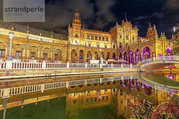 Renaissance-Gebäude auf der Plaza de Espana (Spanien-Platz)  reflektiert auf dem Kanal des Guadalquivir-Flusses  nachts beleuchtet  Sevilla  Andalusien  Spanien  Europa