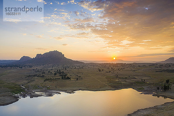 Sonnenaufgang mit Beleuchtung des kleinen Sees und der Gheralta-Berge im Hintergrund  Luftaufnahme mit Drohne  Dugem  Region Tigray  Äthiopien  Afrika