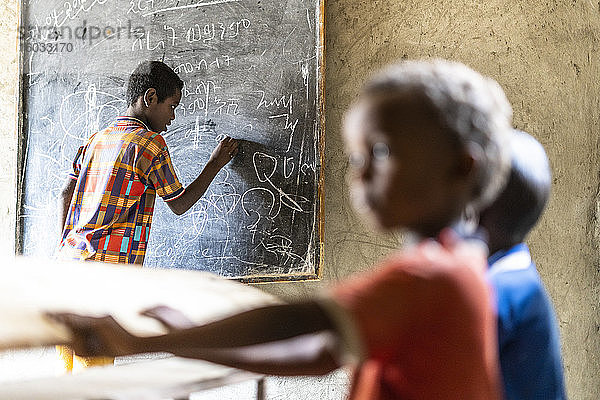 Junge schreibt in der Schule an die Tafel  Melabday  Asso Bhole  Danakil-Depression  Afar-Region  Äthiopien  Afrika