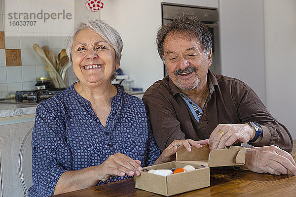 Älterer Mann und Frau halten Geburtstagsgeschenk  Online-Feier während der Coronavirus-Sperre.