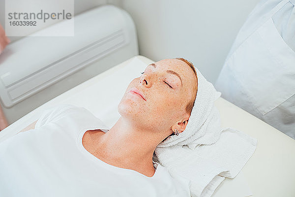 Frau liegt auf einem Behandlungsbett in einem Schönheitssalon.