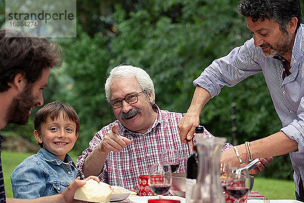 Junge und Grossvater beim Familienessen