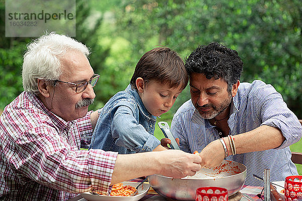 Drei Generationen einer männlichen Familie  die gemeinsam essen