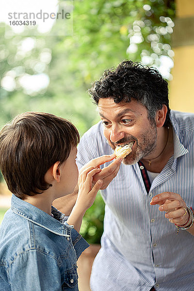 Junge und Vater essen Brot