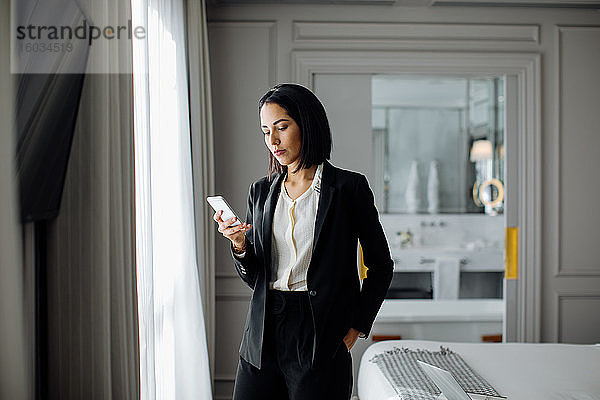 Geschäftsfrau benutzt Smartphone in der Suite