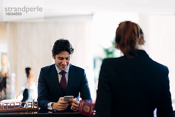 Geschäftsmann  der an der Hotelrezeption eincheckt