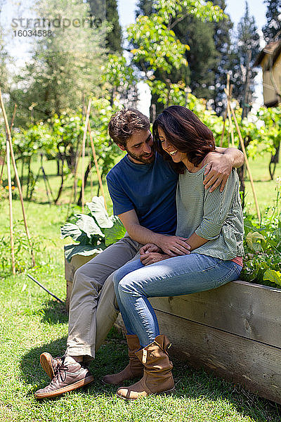 Liebevolles Paar mittlerer Erwachsener  das im Garten sitzt