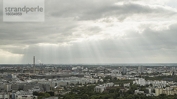 Sonnenstrahlen in Wolken über dem Berliner Stadtbild  Deutschland