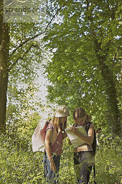 Mädchen mit Notizbuch auf Exkursion im Wald