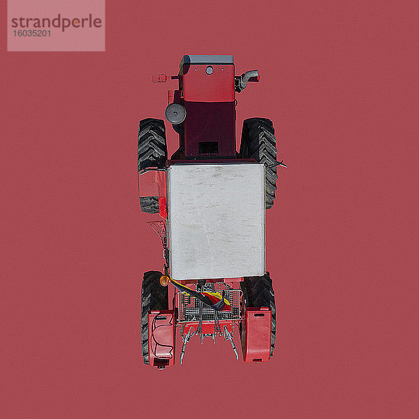 Ansicht von oben Traktor auf rotem Hintergrund