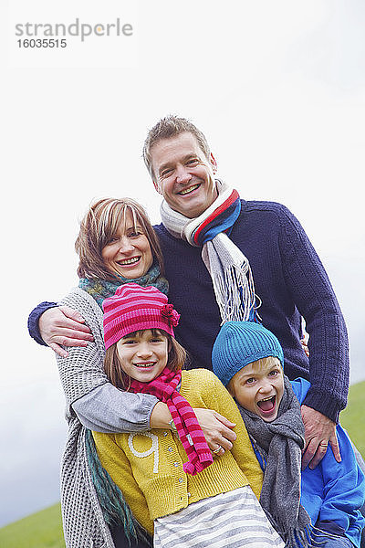 Porträt einer glücklichen Familie mit Hüten und Schals