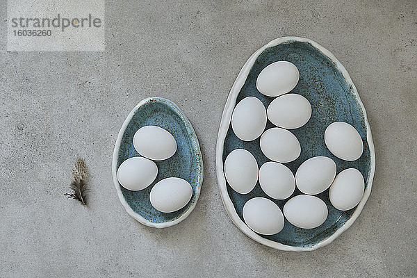 Eiförmige Keramikteller mit weissen Eiern