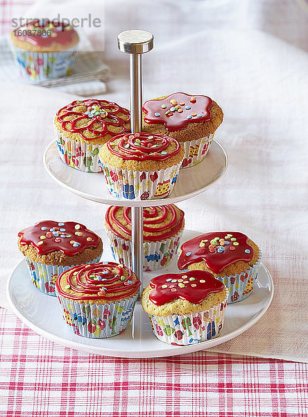 Muffins mit roter Glasur und Zuckerkonfetti auf Etagere