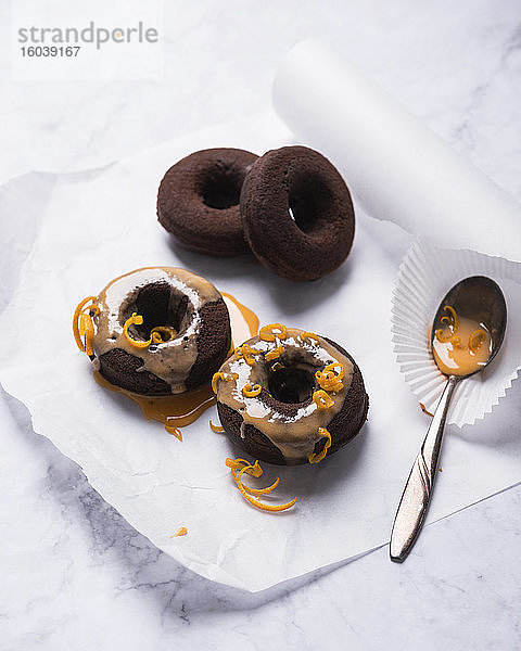 Vegane ofengebackene Schokoladen-Donuts mit Orangenglasur und Orangenzesten