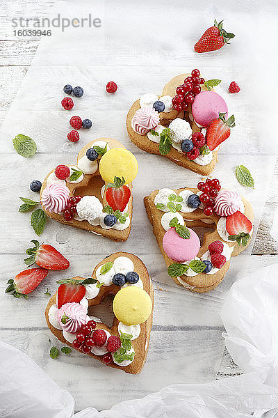 Herzförmige Kuchen mit Baiser  Obst und Macarons