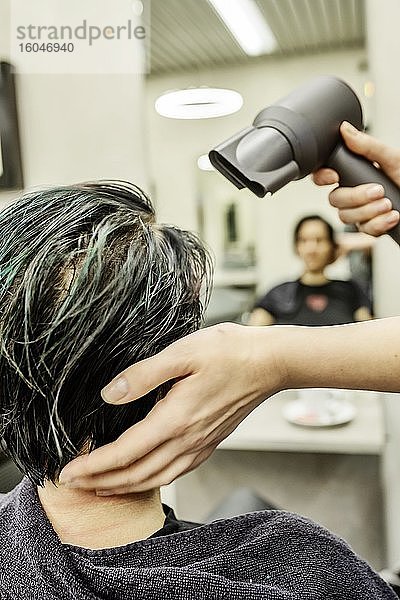 Friseurin in einem Frisiersalon fönt einer Kundin die gefärbten Haare  Köln  Nordrhein-Westfalen  Deutschland  Europa