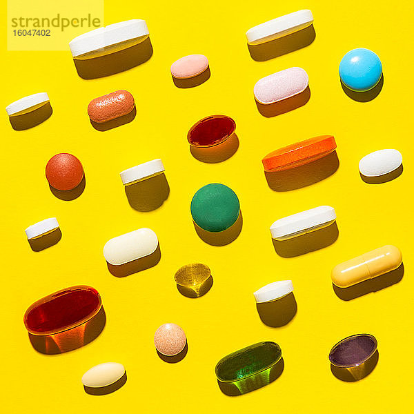 Pillen und Kapseln auf gelb