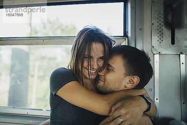 Paar umarmt sich im Zug