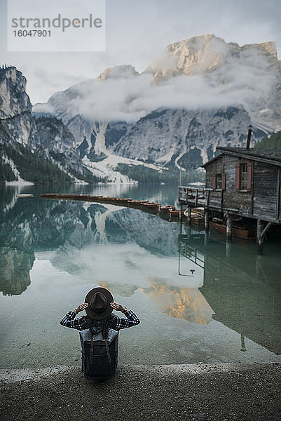 Italien  Frau bei Pragser Wildsee in den Dolomiten sitzend