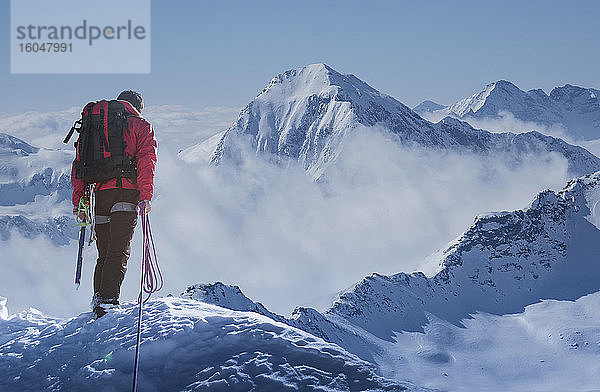 Italien  Alpen  Bergsteiger mit Blick auf verschneite Berglandschaft