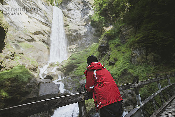 Schweiz  Mann schaut auf Berschner-Wasserfall in den Bergen