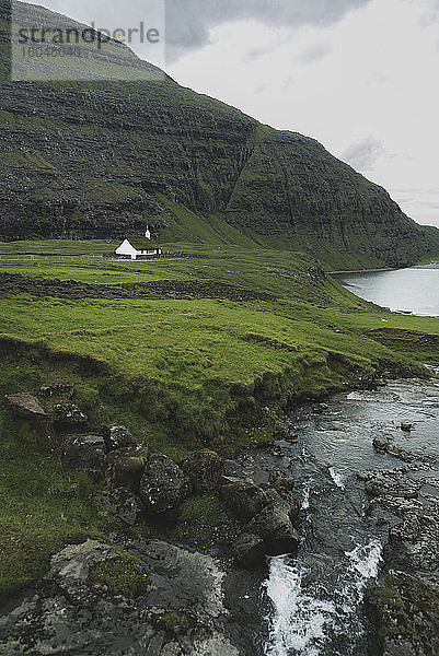 Dänemark  Kleine Kirche in grüner Landschaft mit Bergen und Meer