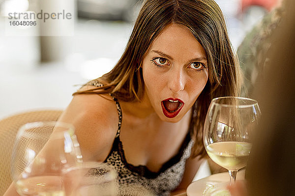 Überrascht junge Frau sitzt im Restaurant