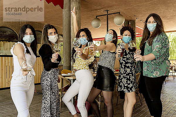 Junge weibliche Kunden mit Getränken in der Hand in einem Restaurant während einer Pandemie