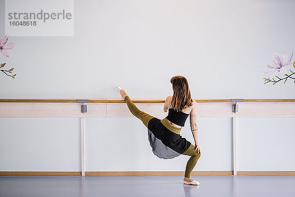 Ballerina streckt das Bein im Tanzstudio
