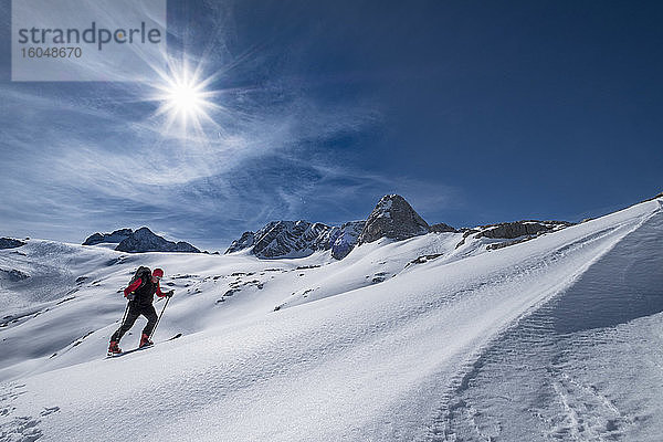 Mann beim Skifahren auf dem schneebedeckten Dachstein gegen den Himmel an einem sonnigen Tag  Österreich