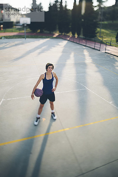 Jugendlicher Basketballspieler mit Ball auf dem Spielfeld
