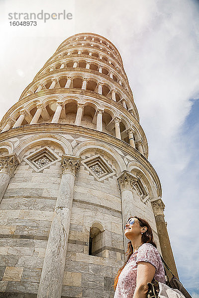 Weibliche Touristin betrachtet den Schiefen Turm von Pisa gegen den Himmel  Pisa  Toskana  Italien