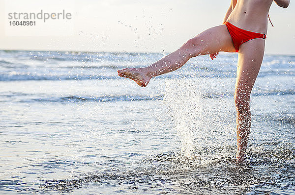 Beine einer Frau  die mit Wasser im Meer plantscht
