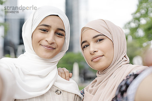 Muslimische Schwestern machen ein Selfie in der Stadt an einem sonnigen Tag