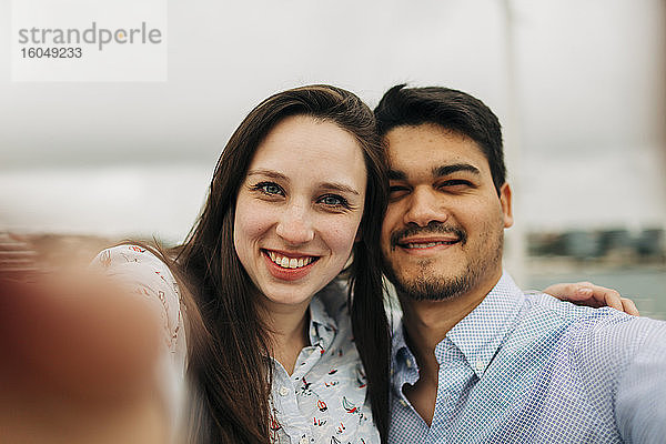 Glückliches Paar nimmt Selfie gegen Himmel