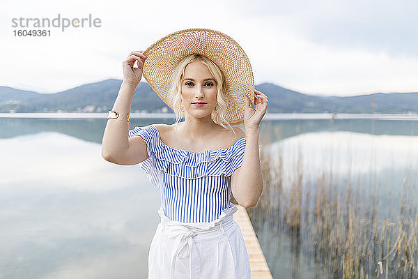 Porträt einer modischen blonden Frau auf einem Steg am Wörthersee  Österreich